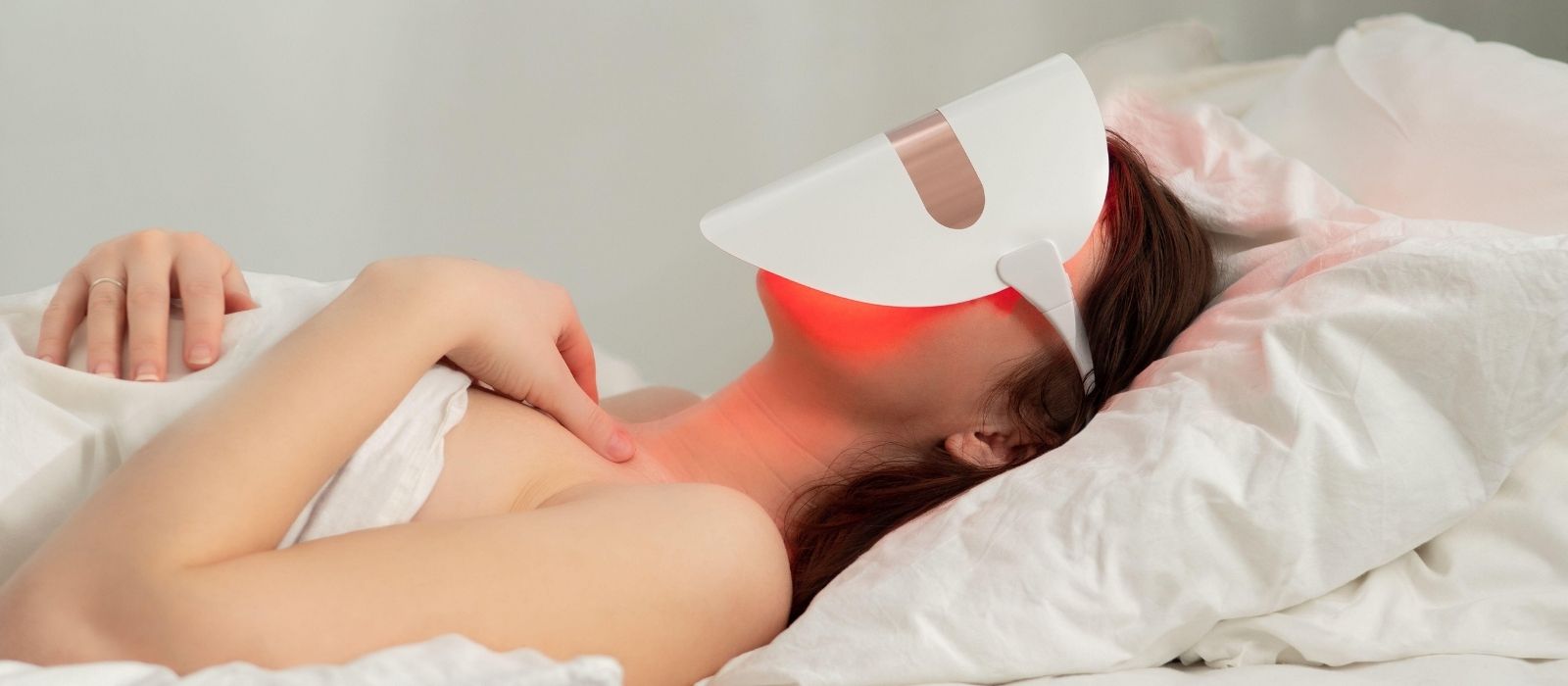 Woman using a red light therapy device at home
