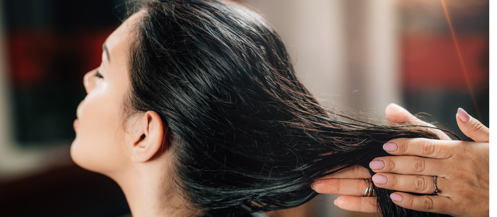Hair oil being applied to scalp in warm light