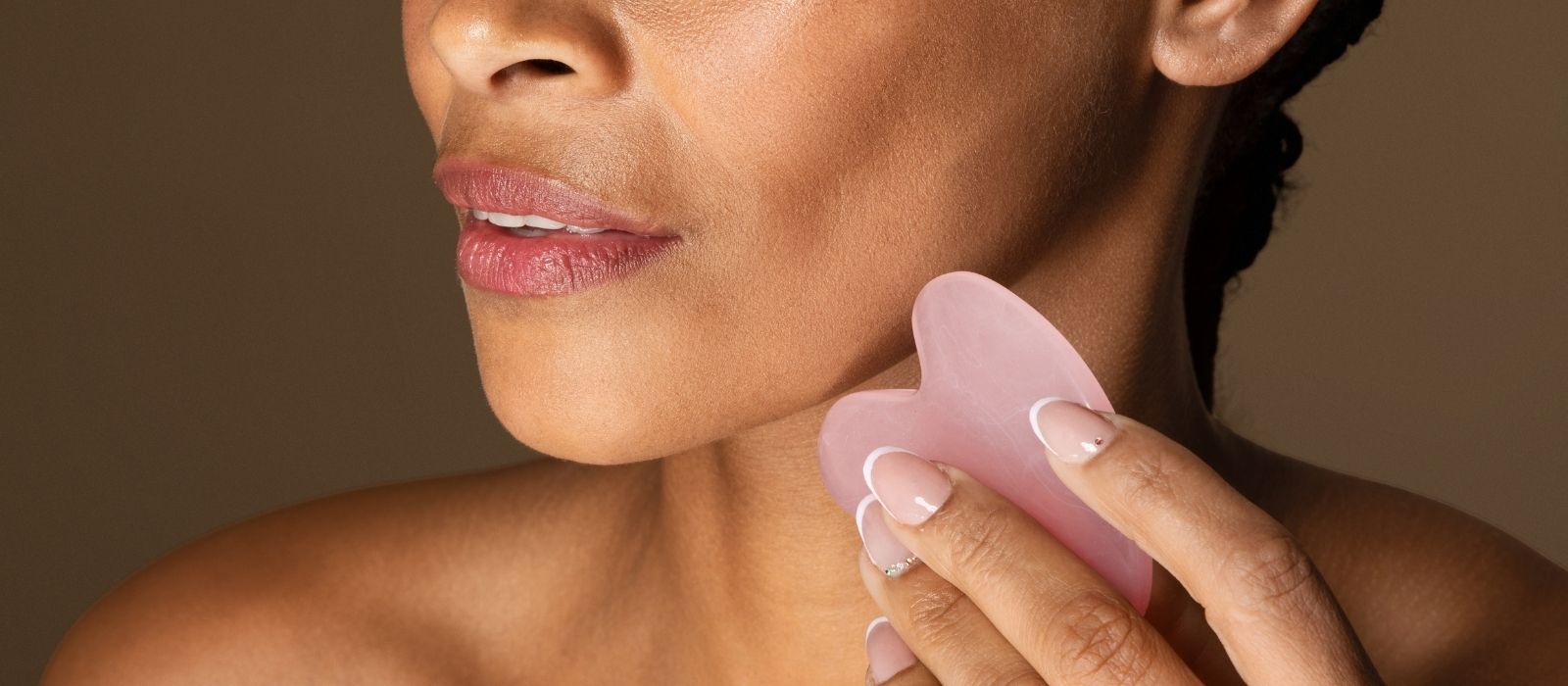 Woman performing gua sha facial massage
