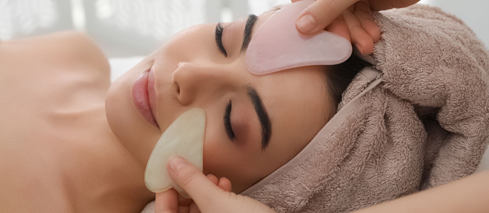 Woman performing gua sha facial massage