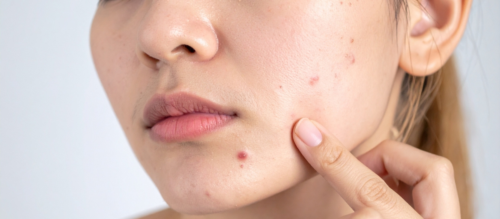 Woman examining clear skin in soft natural light