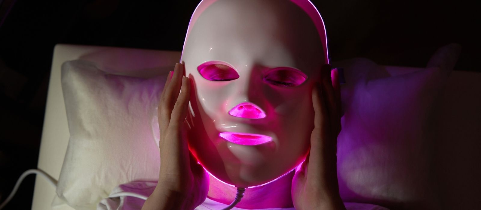 Woman using a red light therapy device at home