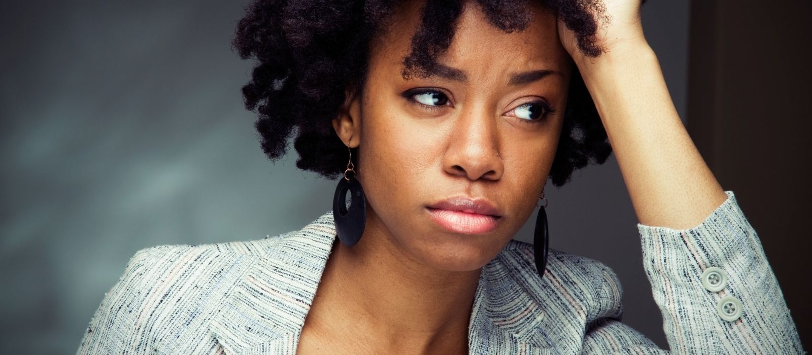 Troubled woman with her hand on her head, looking away