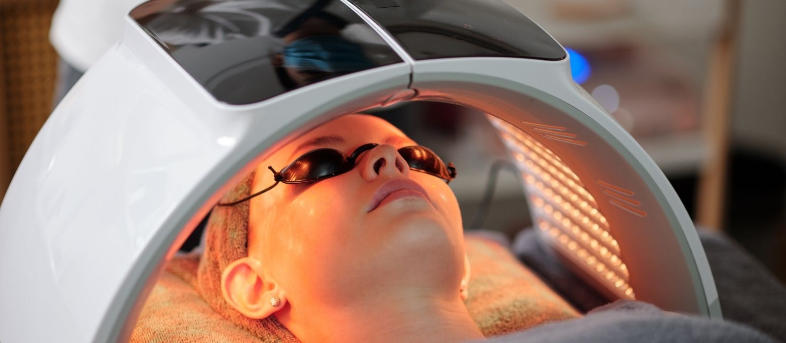 Woman using a red light therapy device at home