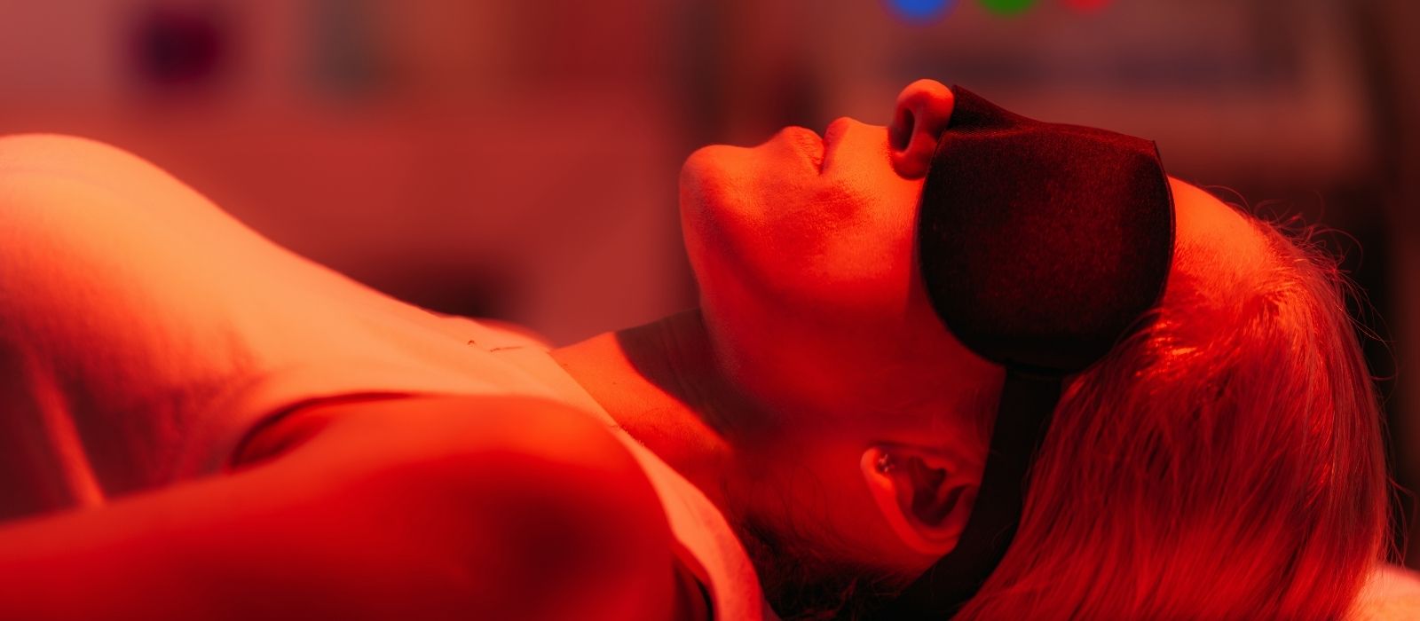 Woman using a red light therapy device at home