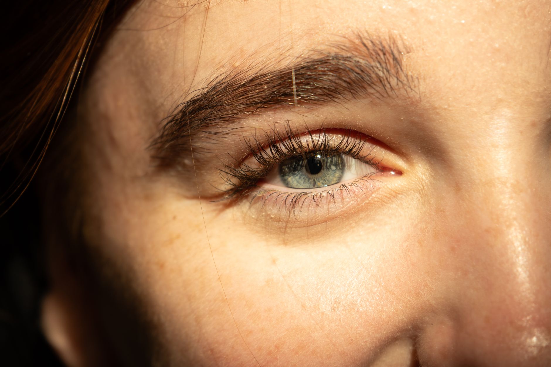 Woman applying serum to calm irritated skin near window