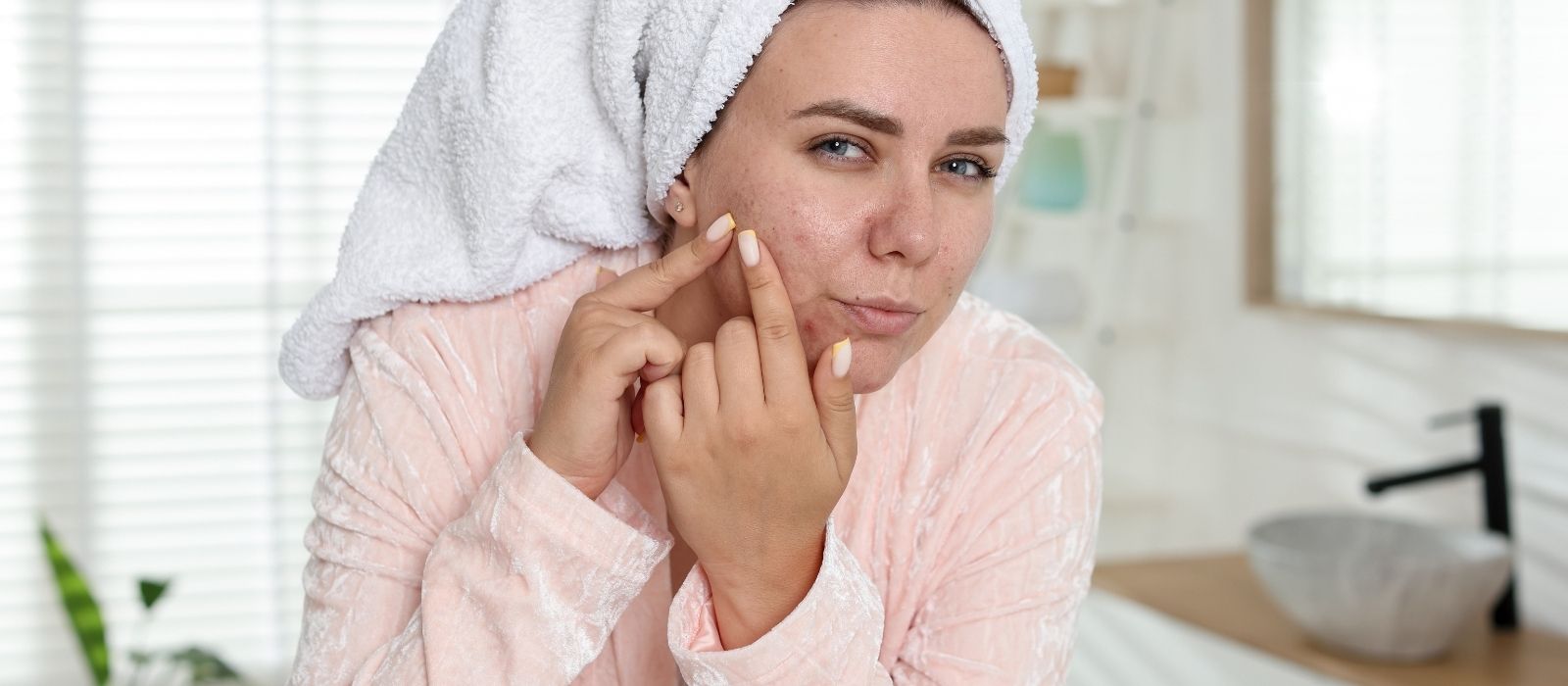Woman examining clear skin in soft natural light