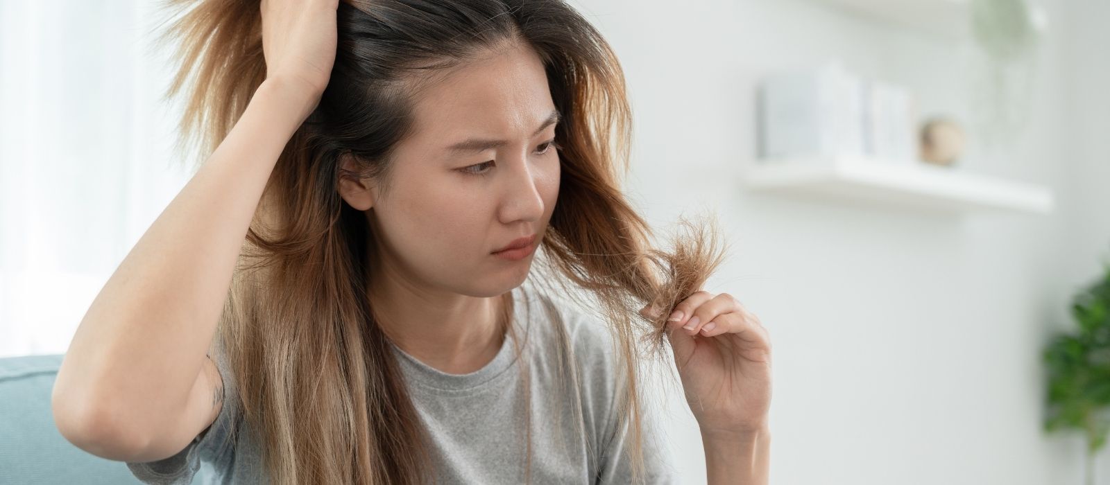 Woman gently touching her hair in soft light