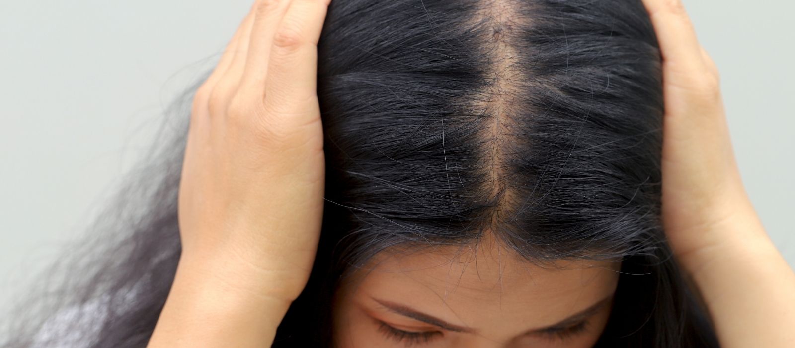 Woman gently touching her hair in soft light