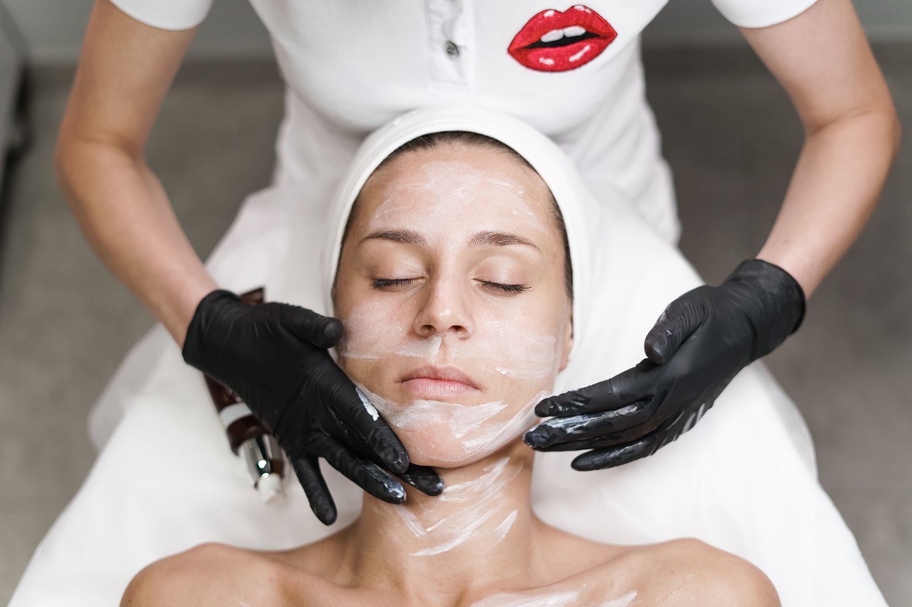 Woman receiving professional facial treatment in a clean spa room
